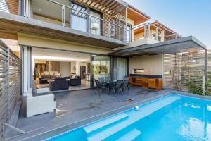 a house with a swimming pool and a living room at Stylish 19 Ocean's Edge 4 Bedroom Home, Zimbali in Ballito