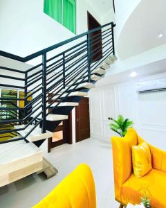 a living room with a staircase and a yellow couch at Lovely 2 bedroom in ikate in Lekki
