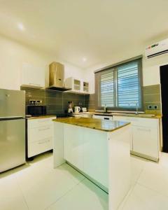 a large kitchen with white cabinets and stainless steel appliances at Lovely 2 bedroom in ikate in Lekki