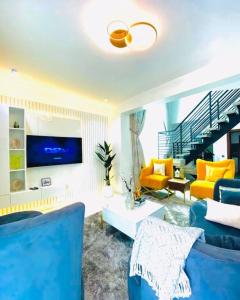 a living room with a blue couch and yellow chairs at Lovely 2 bedroom in ikate in Lekki