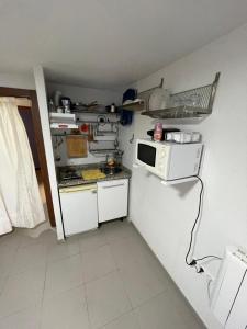 una pequeña cocina con microondas en la pared en Bonito apartamento vistas espectaculares, en Granada