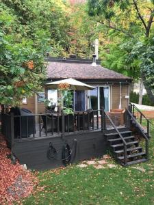Casa pequeña con porche y terraza en Om chalet 2 avec spa et foyer bordé du fleuve, en St-Pierre-de-l'Île-d'Orléans