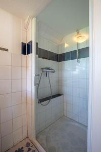La salle de bains est pourvue d'une douche avec une porte en verre. dans l'établissement Mein Haus, à Pellworm