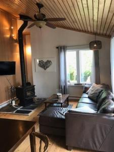 a living room with a couch and a wood stove at Om chalet 2 avec spa et foyer bordé du fleuve in St-Pierre-de-l'Île-d'Orléans