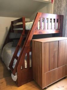 - un lit superposé en bois avec une échelle à côté d'un lit dans l'établissement Om chalet 2 avec spa et foyer bordé du fleuve, à Saint-Pierre-de-l'Île-d'Orléans