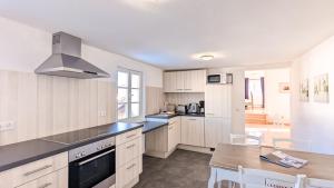 a kitchen with white cabinets and a dining table at Ferienwohnung Krause in Pfronten