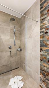 a bathroom with a shower with a stone wall at Chalet am Breitenberg Appartement CB 11 in Pfronten