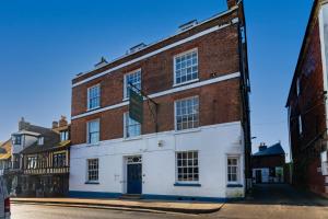 a red brick building with a blue door on a street at The George Hotel in Battle