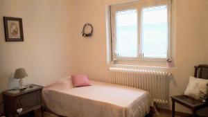 een kleine slaapkamer met een bed en een raam bij Gîte Le bel Epi in Vany