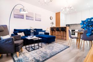 - un salon avec un canapé bleu et une table dans l'établissement ApartamentySnu, Jagielloński Premium, Centrum, à Radom