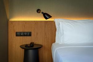 a bedroom with a bed and a lamp and a table at Acta The Clover in Porto