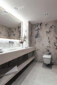 a bathroom with a sink and a toilet and a mirror at City Hotel Dubrovnik in Dubrovnik