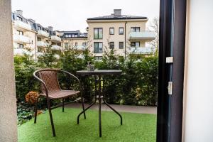 d'une table et d'une chaise sur un balcon avec vue. dans l'établissement ApartamentySnu, Jagielloński Premium, Centrum, à Radom