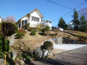 a house on a hill with a landscaping at ■屋根付BBQテラスのある貸別荘■1棟貸しなので安全安心■3台分の無料駐車場完備です in Izu