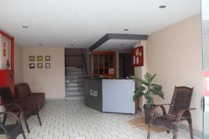 a kitchen with chairs and a refrigerator in a room at Hotel Conceição da Barra in Conceição da Barra