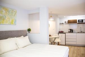 a bedroom with a bed and a small kitchen at Stacey’s Stylish studio in Eilat