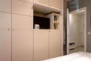 a bedroom with white cabinets and a tv at Apartment Casino in Nieuwpoort