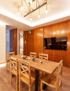 a dining room with a wooden table and a tv at San Bernardino 15 in Madrid