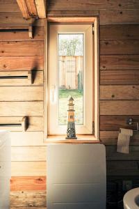 a tiny house with a window and a small lighthouse at Le P'tit Nid : Mini loft pour 2 à 4 personnes in Tellin