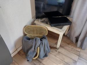ビージャ・ラ・アンゴストゥーラにあるEl Recuerdoのラップトップサイズのテーブルの横に座る籐の椅子