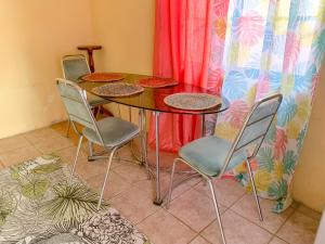 a table and four chairs in a room at Apartment at Trincity Central Road in Port-of-Spain