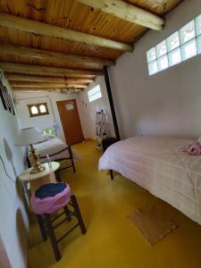 a bedroom with a bed and a table and a chair at La Diamantina, Hospedaje Holistico in San Marcos Sierras
