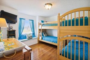 a bedroom with two bunk beds and a desk at Pelican Path in Galveston