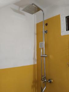 a shower in a bathroom with a yellow wall at La Diamantina, Hospedaje Holistico in San Marcos Sierras