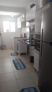 Il comprend une cuisine équipée d'un réfrigérateur et d'un comptoir. dans l'établissement Apartamento para temporada Condomínio Ilha de Noronha Praia Grande SP, à Praia Grande