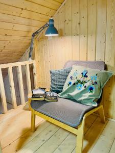 a bench in a cabin with a lamp and books at Osada Chmiel in Chmielno