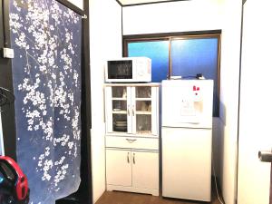 a kitchen with a refrigerator and a microwave at KYOTO Guest House in Kyoto