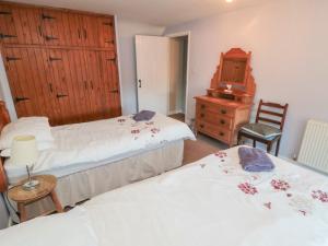 a bedroom with two beds and a dresser and a mirror at Big Cottage in York