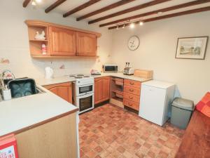 a kitchen with wooden cabinets and a white refrigerator at Big Cottage in York