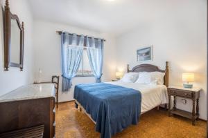 een slaapkamer met een bed met een blauwe deken erop bij Cabo de Sagres -2 bedroom apartment in Sagres