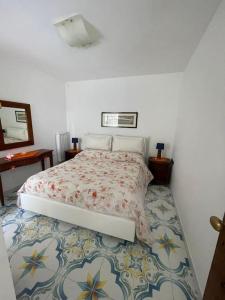 a bedroom with a bed with a patterned floor at Villa sul mare in Massa Lubrense
