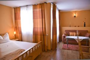 1 dormitorio con cama, sofá y ventana en Pension Zierlinger, en Senftenberg