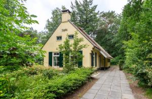 uma casa na floresta com uma passagem em Landgoed 't Wildryck em Diever