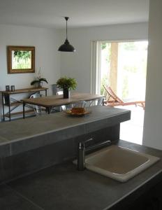 a kitchen with a sink and a table and a dining room at Le mas saint augustin in La Crau
