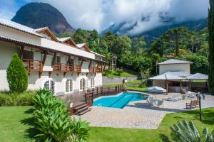 un complexe avec une piscine et des montagnes en arrière-plan dans l'établissement Mansão cinematográfica. Em busca de seis estrelas!, à Petrópolis