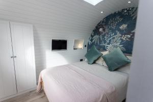 滕比的住宿－The Lodge @Quarrywood，一间卧室配有一张带花卉壁纸的大床