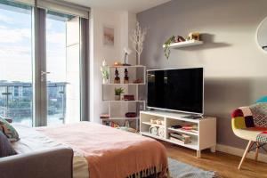 ein Wohnzimmer mit einem Flachbild-TV und einem Sofa in der Unterkunft Stunning Mersey-View Luxury Apartment with Allocated Secure Parking Space in Liverpool