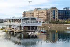 a building on a dock in the water with boats at Stunning Mersey-View Luxury Apartment with Allocated Secure Parking Space in Liverpool