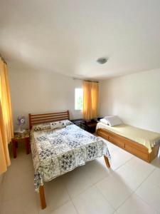 1 dormitorio con 2 camas y ventana en apartamento de frente para o mar en Vera Cruz de Itaparica