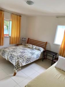 a bedroom with two beds and a window at apartamento de frente para o mar in Vera Cruz de Itaparica
