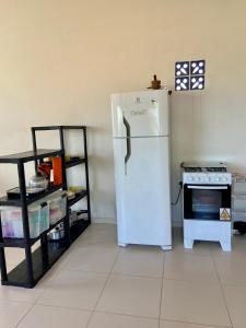 a kitchen with a white refrigerator and a stove at apartamento de frente para o mar in Vera Cruz de Itaparica