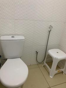 uma casa de banho com um WC branco e um banco em apartamento de frente para o mar em Vera Cruz de Itaparica