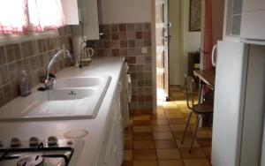 a white kitchen with a sink and a stove at "villa mona" a 700 m de la mer in Grimaud +9 photos