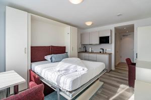 1 dormitorio con 1 cama y cocina en Huber Living Basic 109 en Germering