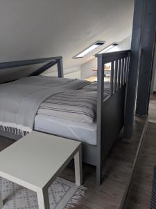 1 dormitorio con cama y banco blanco en Urlaub im Kunstatelier, en Runkel