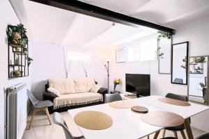 a white living room with a table and chairs at vélodrome F4 dans villa 5 lits parking et piscine partagee in Marseille